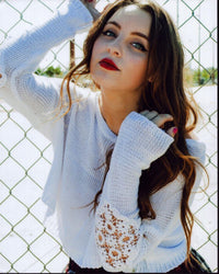 Alexa Losey leaning on fence in white sweater photo print.