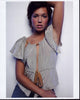 Mandy Moore photo print in gray ruffle top with arm raised
