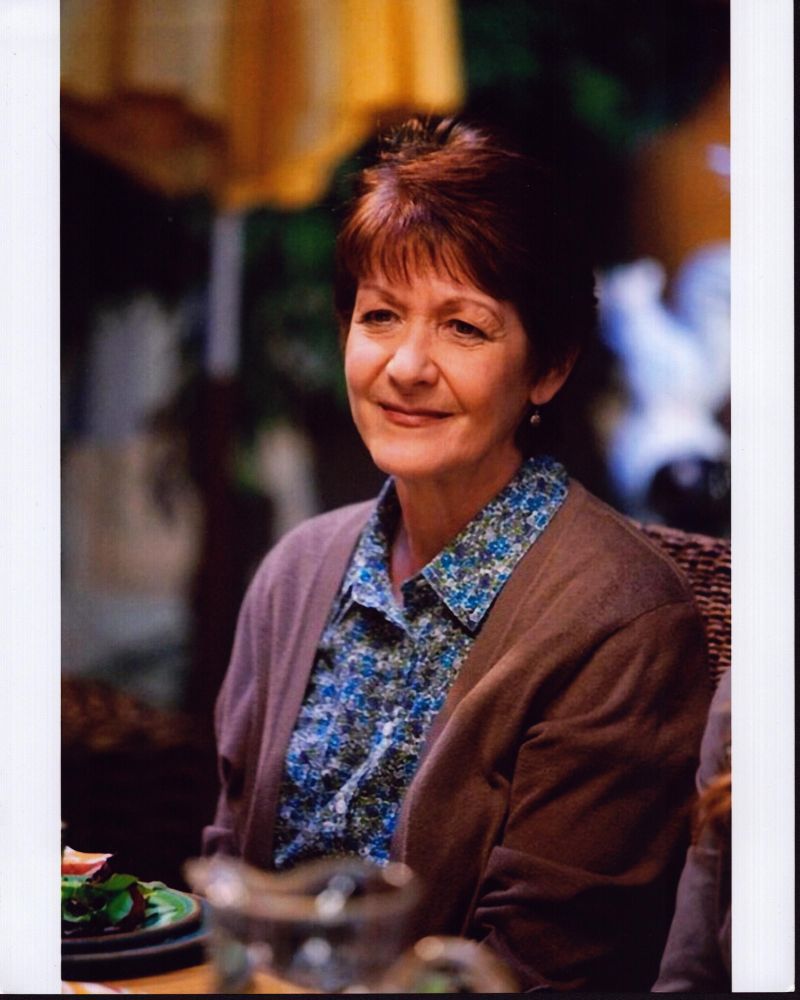 Ivonne Coll sitting in blue floral top with sweater photo print