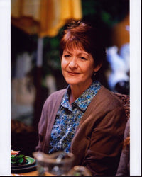 Ivonne Coll sitting in blue floral top with sweater photo print