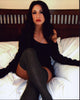 Photo print of Christina Bach sitting on bed in gray thigh highs.