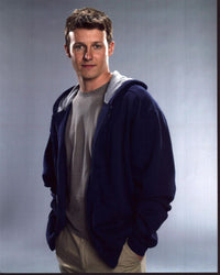Will Estes photo print in sweatshirt with hands in pockets.