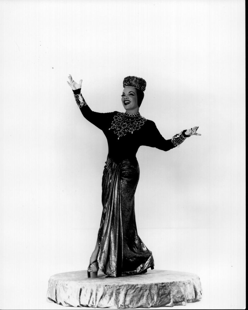 Carmen Miranda posed with arms up in a black and white photo print