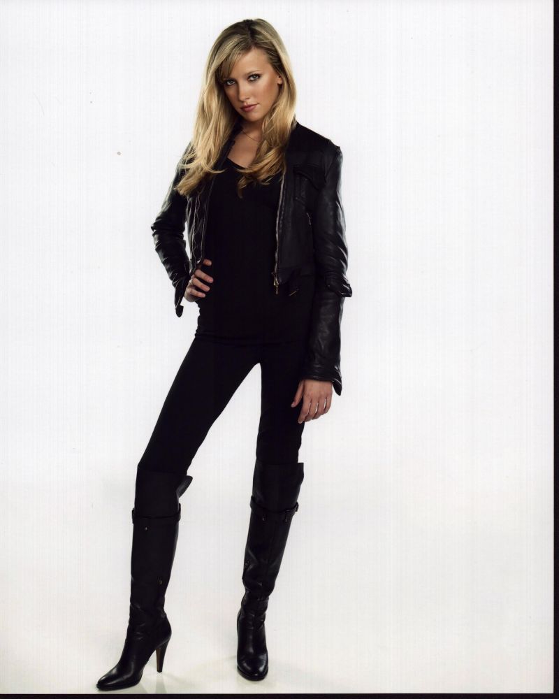 Katie Cassidy photo print in black outfit with hand on hip.