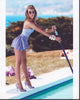 Katie Cassidy posed by the pool in a vibrant photo print.