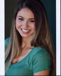 Ayla Kell smiling headshot photo print in a green shirt.