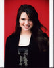 Katie Stevens headshot photo print featuring a black sweater on a red background.