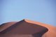Red Sand Dunes Poster Print by Michele Molinari displaying vibrant Sahara landscape.