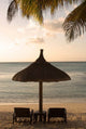 Mauritius beach scene poster print featuring umbrella, chairs, and palm fronds by Peter Skinner