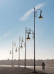 Asilah Morocco Bicycle Ride Poster Print featuring a man riding past lampposts