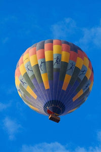 Rainbow hot air balloon soaring over the Namib Desert in Namibia