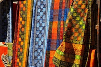 Cloth Stall African Curio Market Poster Print by David Wall showcasing vibrant colors and cultural details.