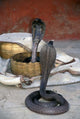 Snake Charming Art Print by Judith Haden showcasing a vibrant scene of snake charmers in India.