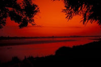 Sunset on Mekong River and Boats Poster Print by Bill Bachmann