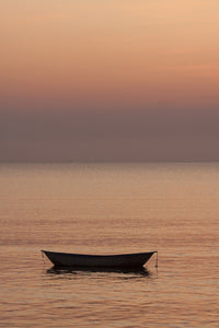 Rowboat at anchor in water at sunset poster print by Tom Haseltine.