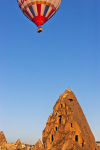 Hot air balloon over Uchisar houses in Cappadocia, Turkey poster print.