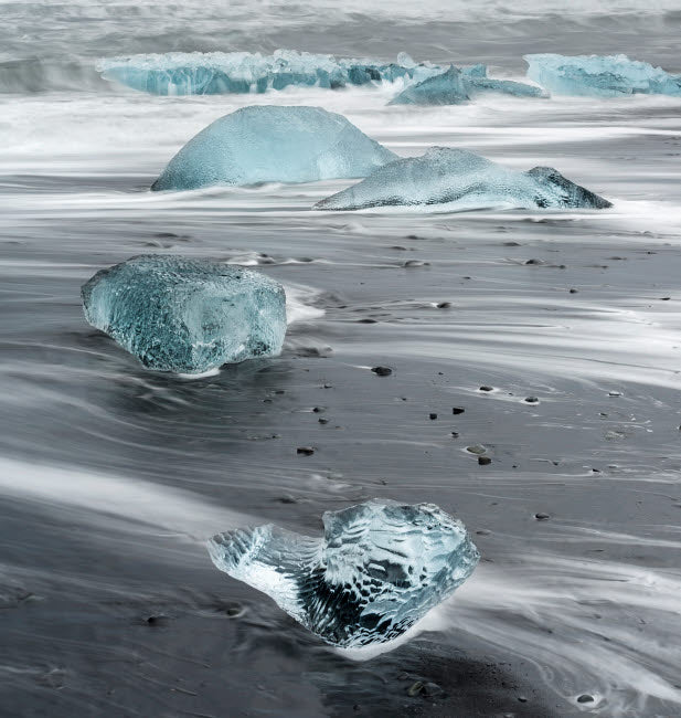 Icebergs on black volcanic beach near Jokulsarlon lagoon in Iceland.