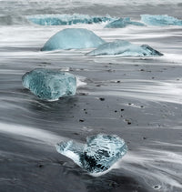 Icebergs on black volcanic beach near Jokulsarlon lagoon in Iceland.