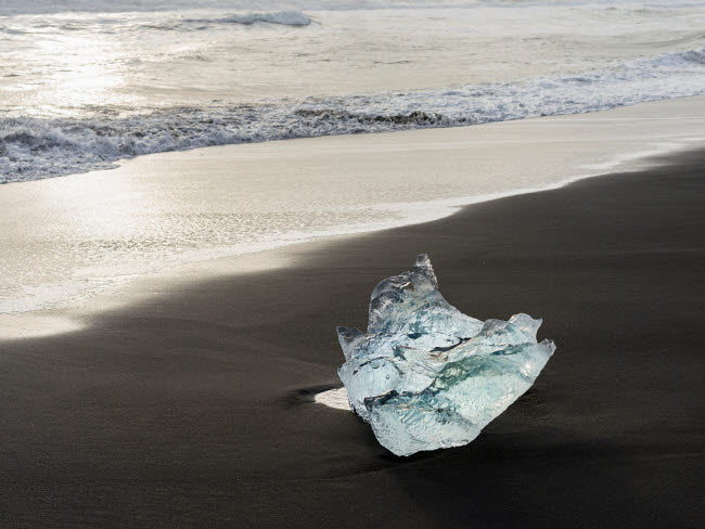 Icebergs on black volcanic beach near Jokulsarlon Glacial Lagoon, Iceland.