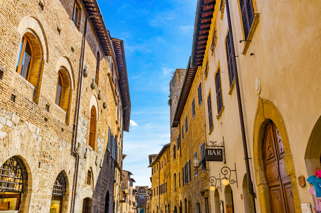 Hotel and Bars on Medieval Street, San Gimignano Art Print by William Perry