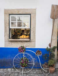 Charming bicycle planter in front of a bakery in Obidos, Portugal - Poster Print by Julie Eggers