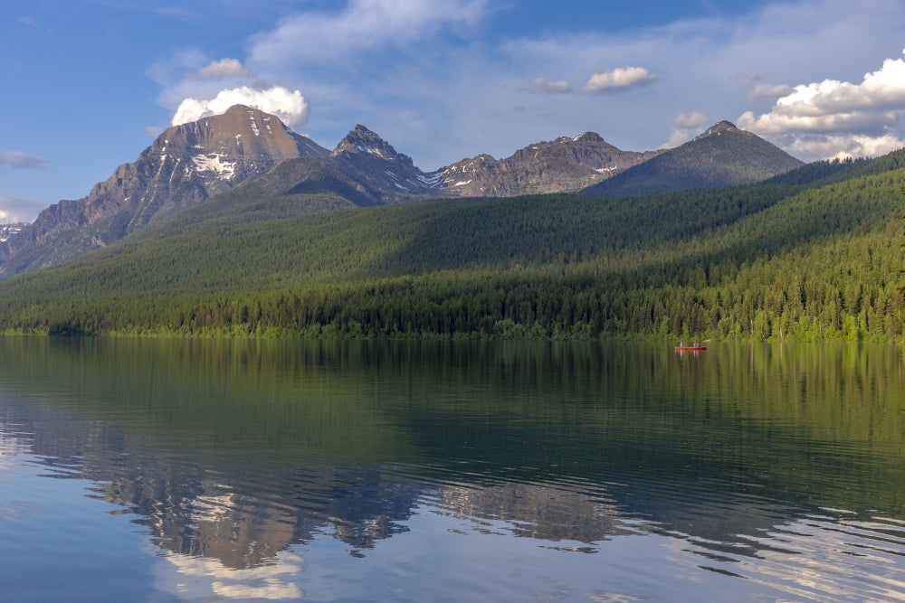 Fishing from a red canoe on calm waters of Bowman Lake in Glacier National Park, Montana art print by Chuck Haney.