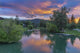 Sunset on Whitefish River poster print by Chuck Haney, showcasing vibrant sunset colors reflecting on water.
