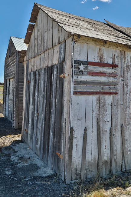 Flag on Side of Old Wooden Shed Poster Print by Darrell Gulin