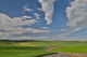 Gravel dirt road running through rolling hills planted in wheat, Eastern Washington poster print by Darrell Gulin.