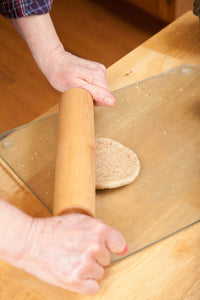 Woman rolling multigrain bread dough into hamburger buns poster print by Janet Horton.