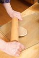 Woman rolling multigrain bread dough into hamburger buns poster print by Janet Horton.