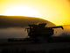 Combine Harvesting at Sunset Poster Print by Terry Eggers