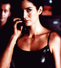Carrie-Anne Moss as Trinity in The Matrix holding a phone photo print