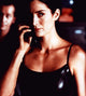 Carrie-Anne Moss as Trinity in The Matrix holding a phone photo print