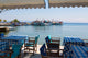 Poster print of Platanias, Thessaly, Greece showing a harbour scene with tables, chairs, and fishing boats.
