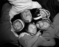 1960s Football Huddle Print showcasing five boys in helmets and jerseys from inside the huddle.