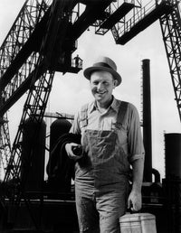 1930s print of a man worker with lunch pail in front of factory
