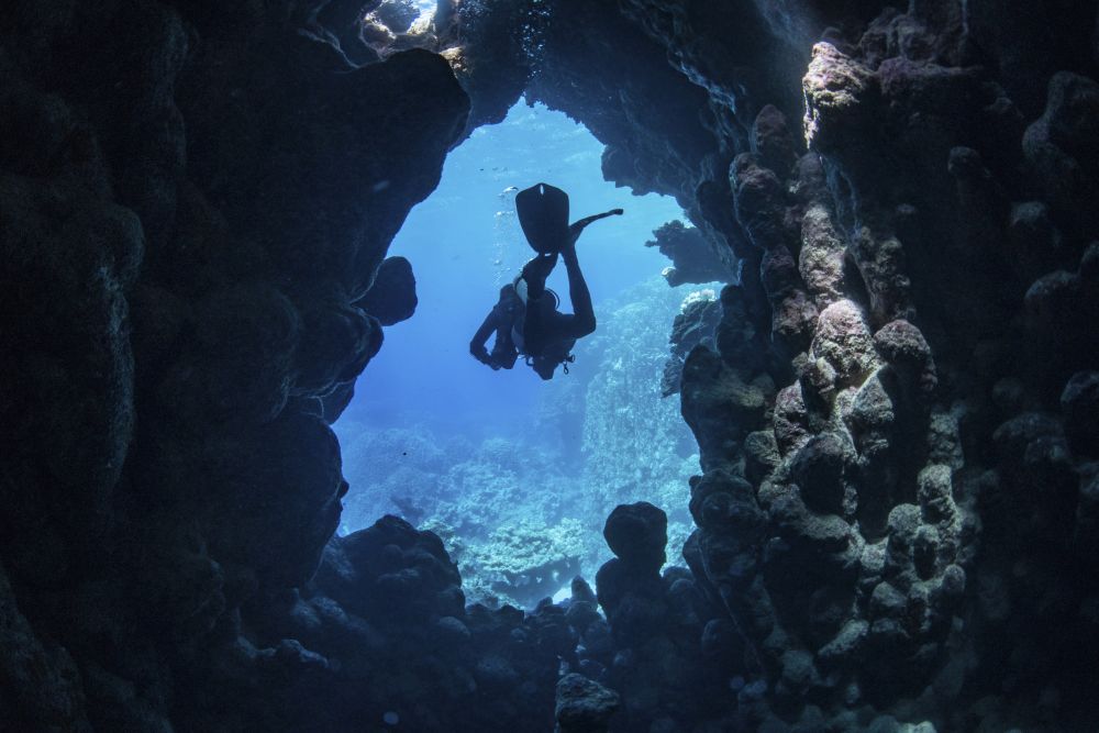 Diver exiting an underwater cave in the Red Sea poster print by Brook Peterson.
