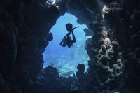 Diver exiting an underwater cave in the Red Sea poster print by Brook Peterson.