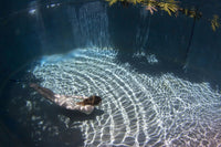 Underwater view of a woman swimming in a pool on Curacao by David Fleetham.