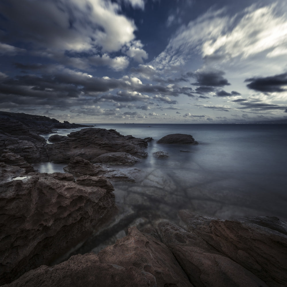 Huge rocks on the shore of a sea against a cloudy sky in Portoscuso, Sardinia, Italy.