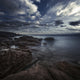 Huge rocks on the shore of a sea against a cloudy sky in Portoscuso, Sardinia, Italy.
