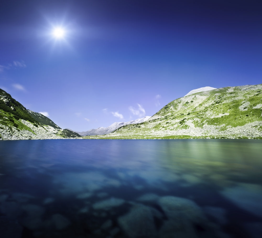 Okoto Lake in Pirin Mountains against blue sky and sun poster print