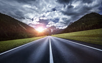 Asphalt road in the Dolomite Alps under moody clouds in Northern Italy.