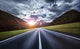 Asphalt road in the Dolomite Alps under moody clouds in Northern Italy.