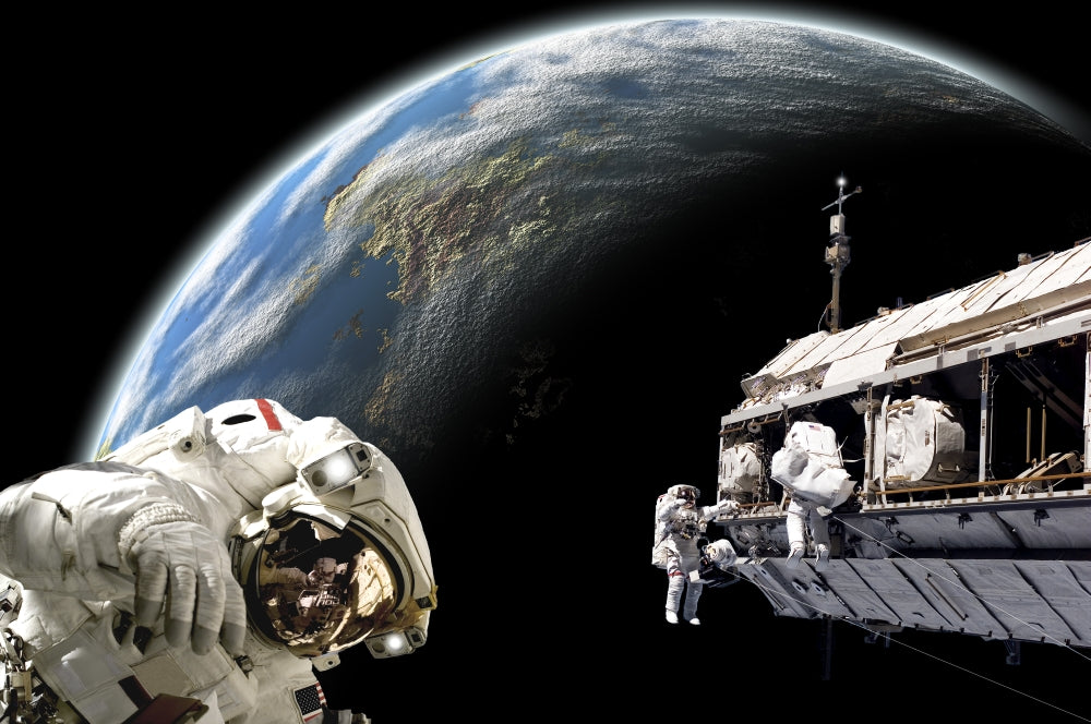 Astronauts working on a space station poster print with Earth-like planet.