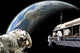 Astronauts working on a space station poster print with Earth-like planet.