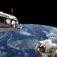 Astronauts performing work on a space station above Earth with Florida and the Bahamas below.