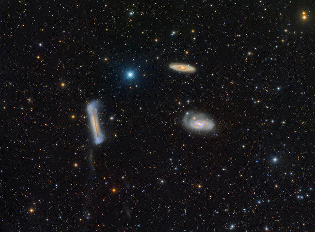 The Leo Triplet Poster Print showcasing three galaxies in vibrant colors.