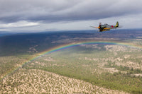 Japanese A6M Zero and Ki-43 Oscar flying in formation above a rainbow.